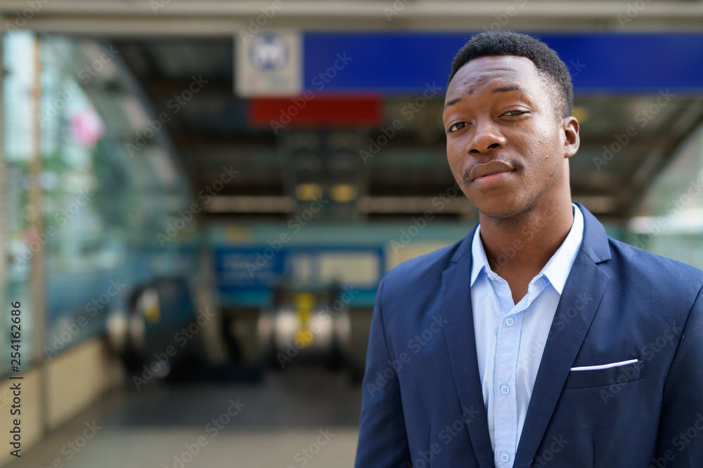 Fototapeta premium Young handsome African businessman outside the subway train station
