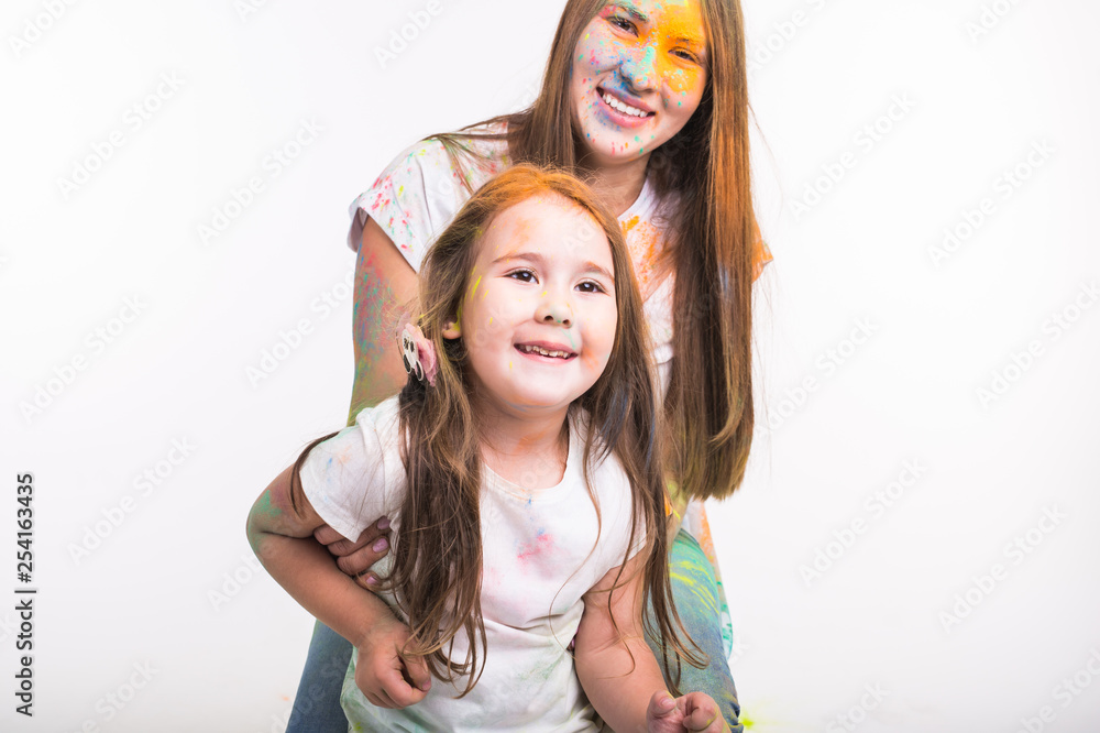 Family, holidays and festival of holy concept - dirty young woman and cute little girl having fun together on white background
