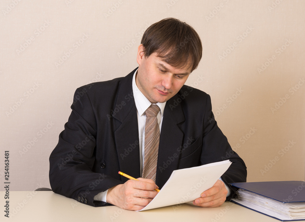 Employee with documents at the table in the office Employee with documents at the table in the office