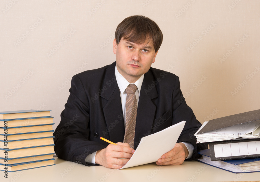 Employee with documents at the table in the office Employee with documents at the table in the office