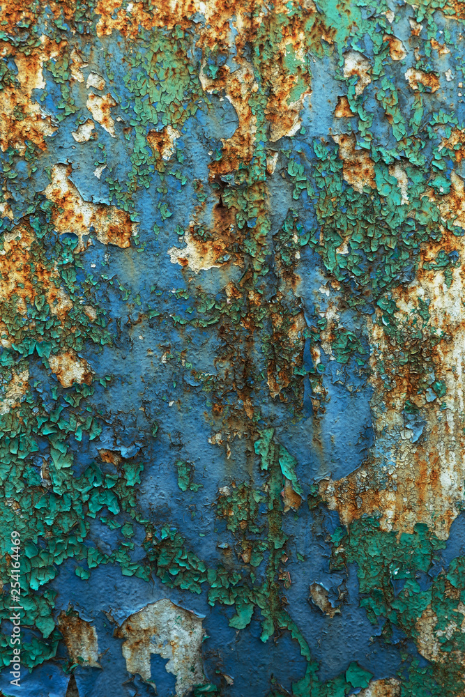 Rusty metal wall, old iron sheet, covered with rust with multi-colored paint. Trace of remnant of old paint in large deep crack on texture of surface rusty metal. Background texture old paint on metal Rusty metal wall, old iron sheet, covered with rust with multi-colored paint. Trace of remnant of old paint in large deep crack on texture of surface rusty metal. Background texture old paint on metal