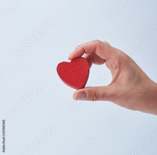 red heart in a human hand on a white background