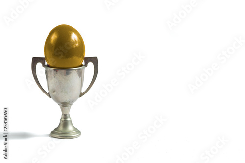 gold egg in a silver cup isolated on white