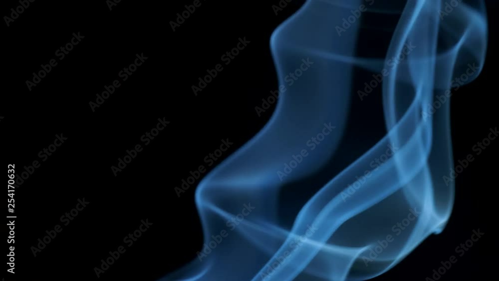 Thin trickle of blue smoke slowly rising graceful twists up on black background. Smoke billow rising swirl to top on black background. Closeup Thin trickle of blue smoke slowly rising graceful twists up on black background. Smoke billow rising swirl to top on black background. Closeup