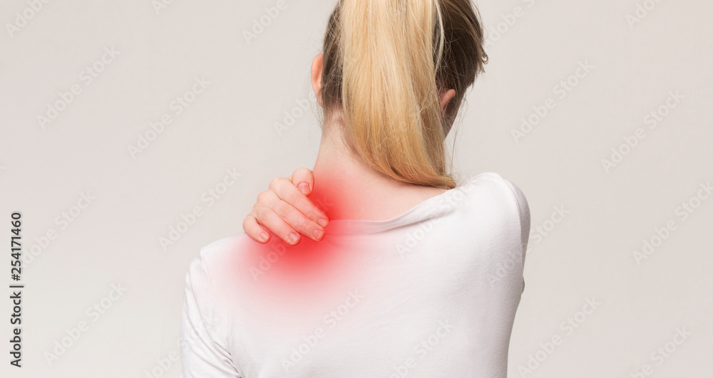 Obraz premium Unhappy woman suffering from pain, massaging neck