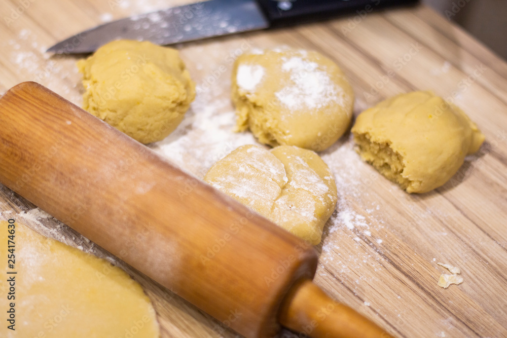background. a wooden rolling pin with the test lie on a table background. a wooden rolling pin with the test lie on a table