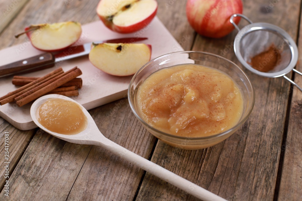 homemade apple jam, with fresh apples and spices with wooden spoon on wooden rustic table homemade apple jam, with fresh apples and spices with wooden spoon on wooden rustic table