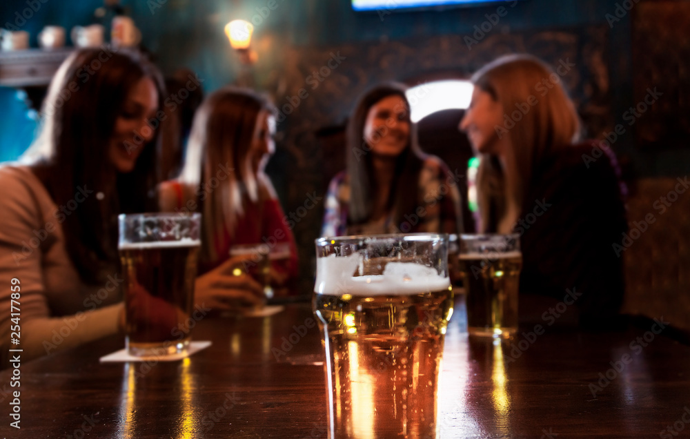group of millennial women having fun drinking beer