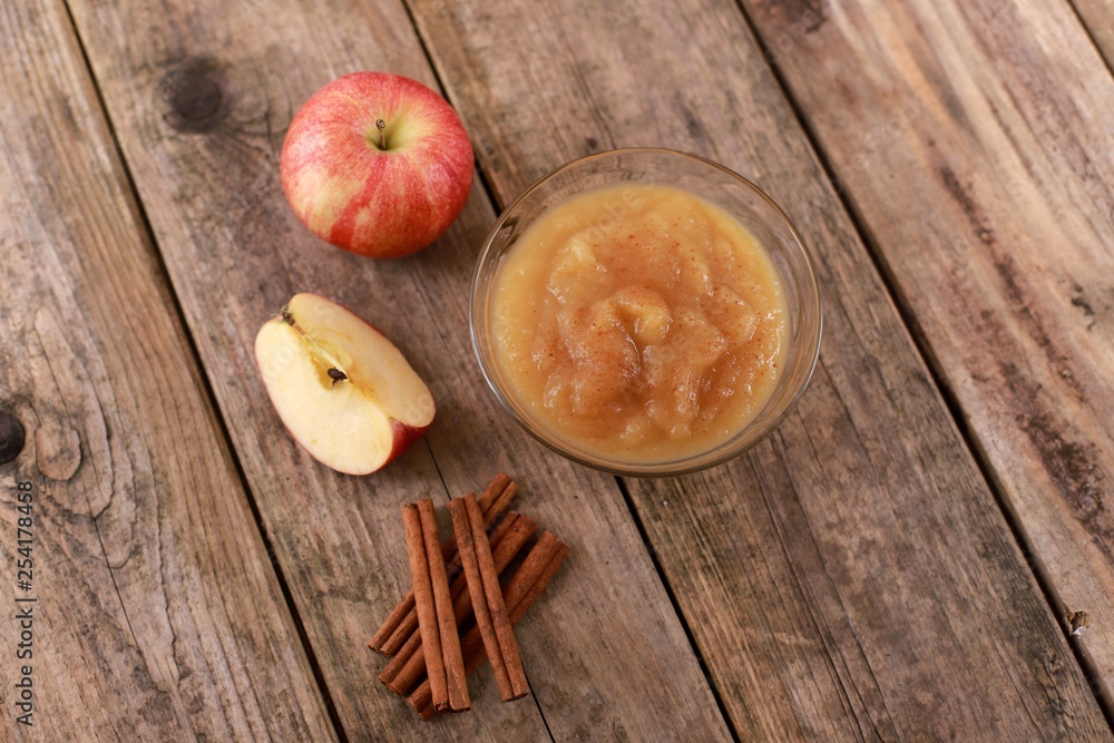 fresh homemade apple jam, apple puree with cinnamon in a bowl and apples on wooden rustic table fresh homemade apple jam, apple puree with cinnamon in a bowl and apples on wooden rustic table