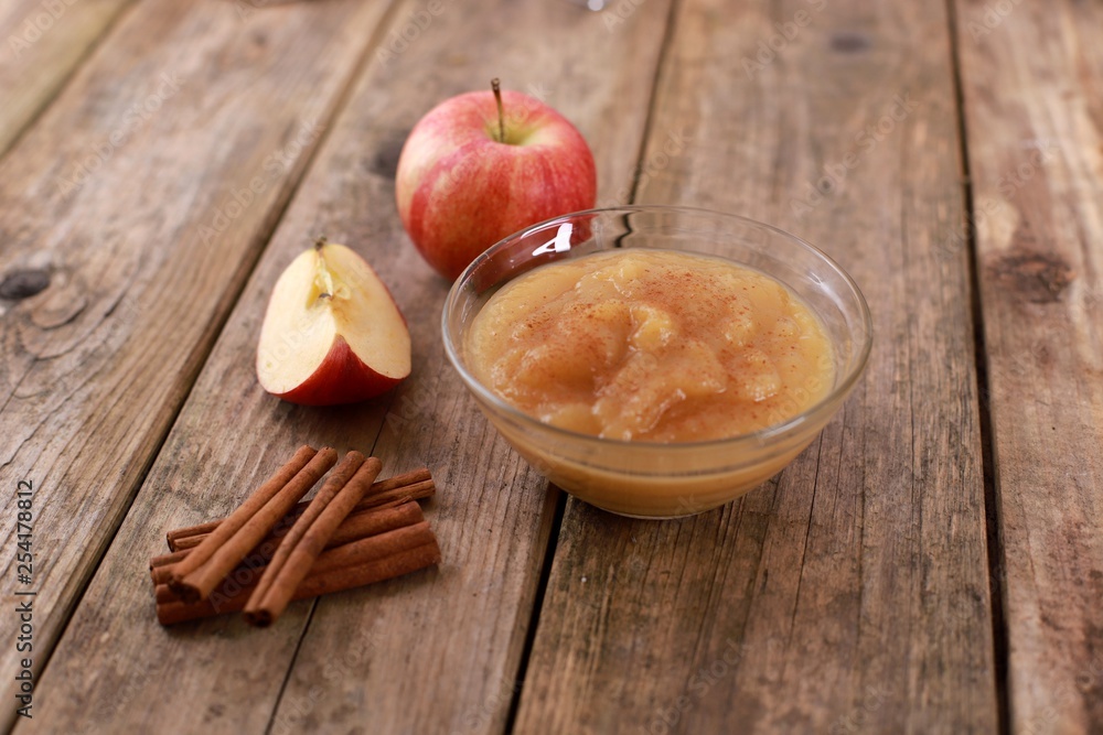 fresh homemade apple jam, apple puree with cinnamon in a bowl and apples on wooden rustic table fresh homemade apple jam, apple puree with cinnamon in a bowl and apples on wooden rustic table