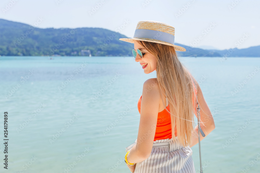 Beautiful girl posing near the lake with mountains in background