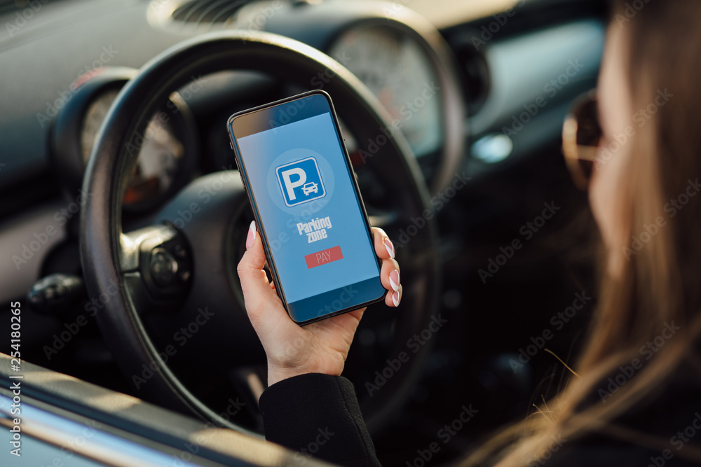 Girl using smartphone app to pay for the parking. Girl using smartphone app to pay for the parking.