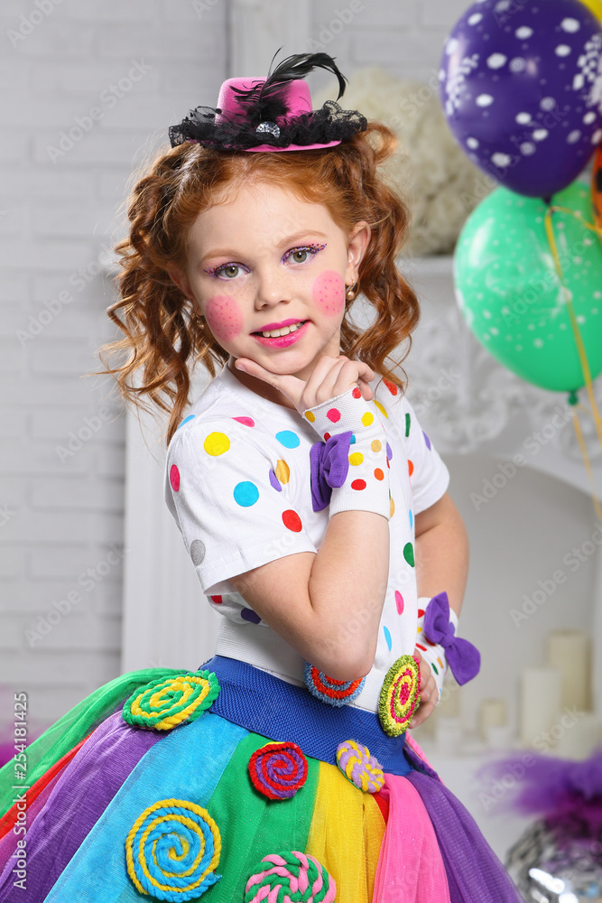  A little girl in bright color carnival clothes, with bright make-up.