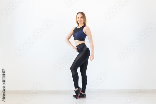 People, fitness and sport concept - standing young sporty woman on white background © satura_