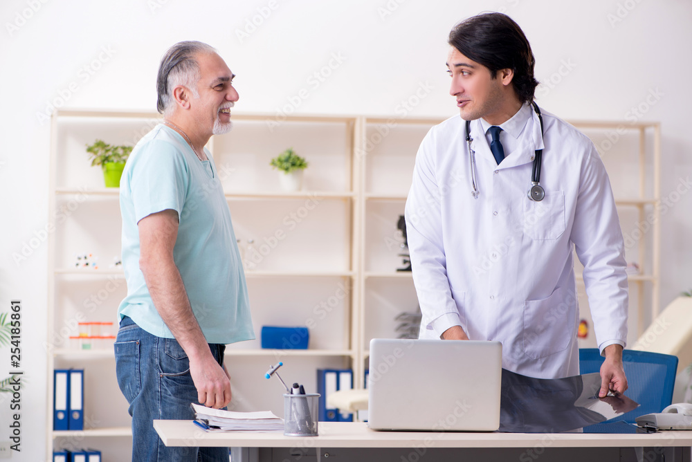 Old man visiting young male doctor Old man visiting young male doctor