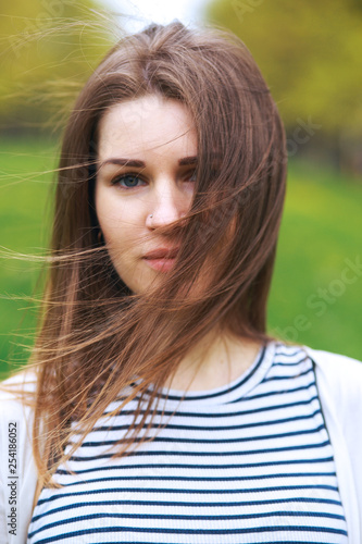 Close-up portrait of young woman in park in summer