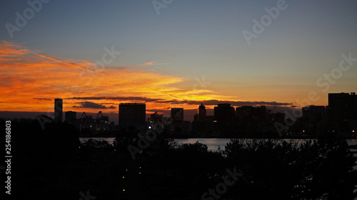 Silhouette of buildings in Asia city with evening sunset and orange sky background.