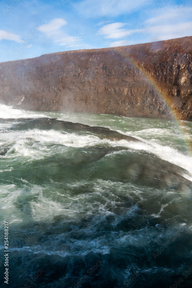 landscape overlooking the waterfall with a rainbow - Iceland, Gullfoss - vertical Image