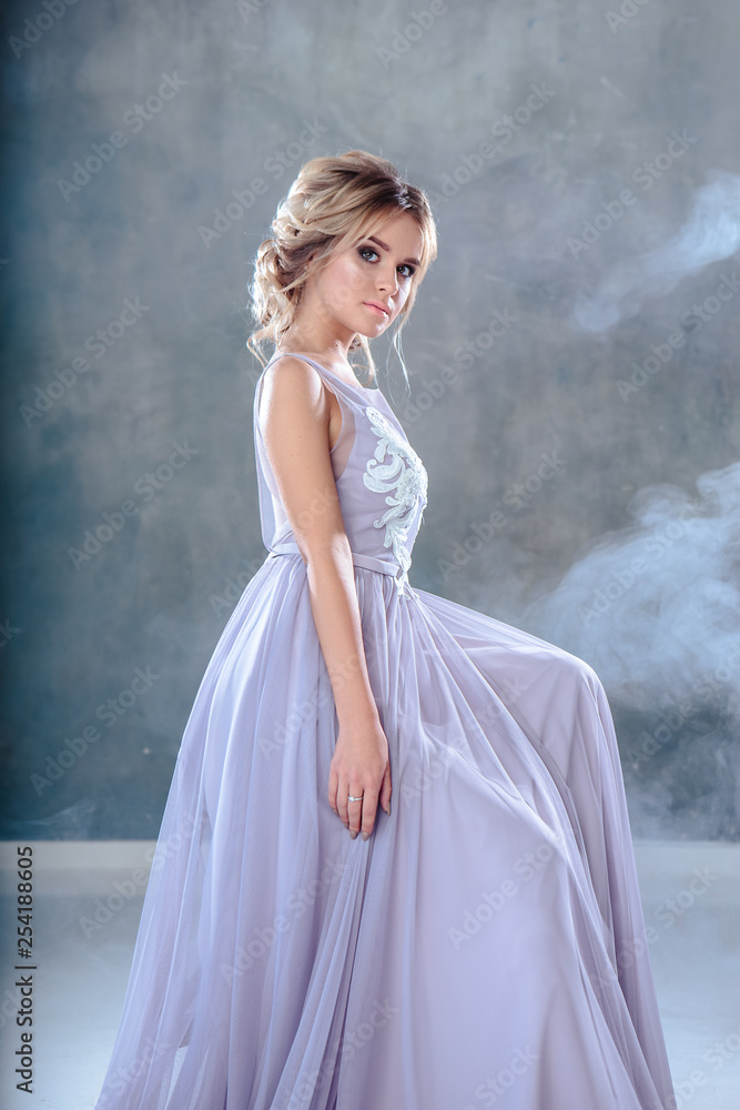 Bride blonde woman in a modern color wedding dress with elegant hair style and make up. Fashion beauty portrait over textured background Bride blonde woman in a modern color wedding dress with elegant hair style and make up. Fashion beauty portrait over textured background