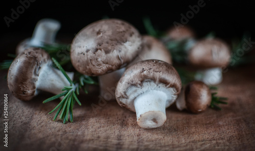 royal mushrooms on a wooden slab with rosemary