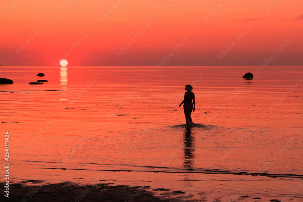 Girl and red sunset on the sea