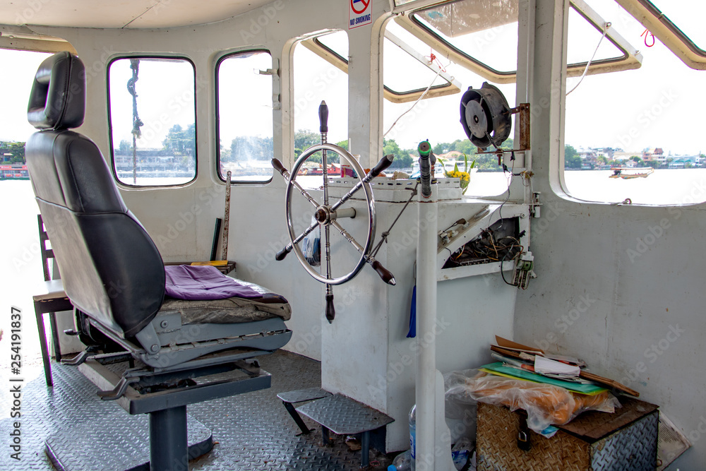The wheelhouse on a ferry boat in Thailand. The empty control cabin on ship  on the Chao Phraya River in Bangkok. Stock Photo | Adobe Stock