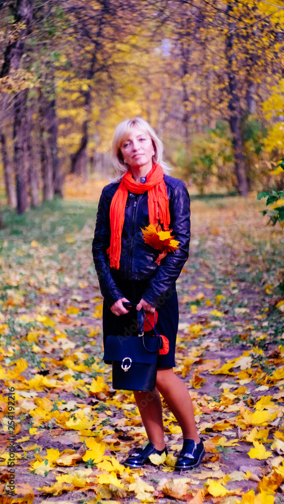 bright beautiful happy blonde woman with blue eyes in black dress on a walk in the Park. bright beautiful happy blonde woman with blue eyes in black dress on a walk in the Park.
