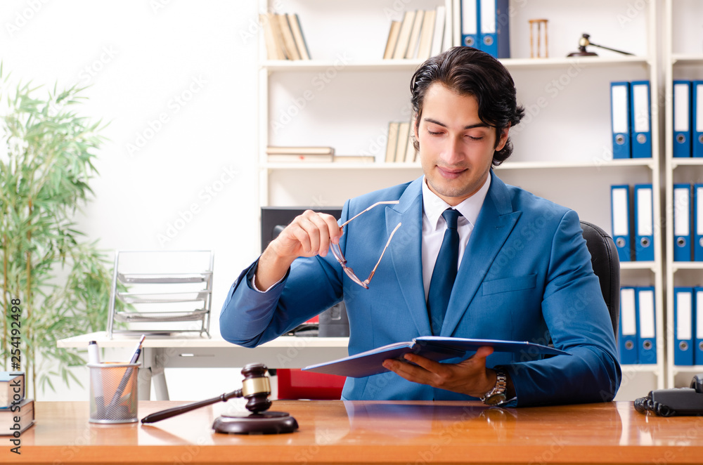 Young handsome judge sitting in courtroom Young handsome judge sitting in courtroom
