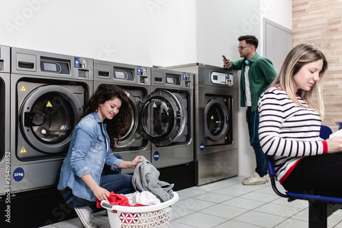 Cuadro en lienzo Young people at laundromat shop.