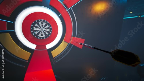 Player throwing a dart hitting perfectly in the bullseye of the dartboard. photo