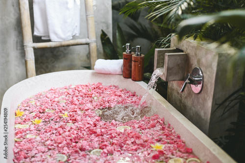 Bath tub with flower petals filling with water