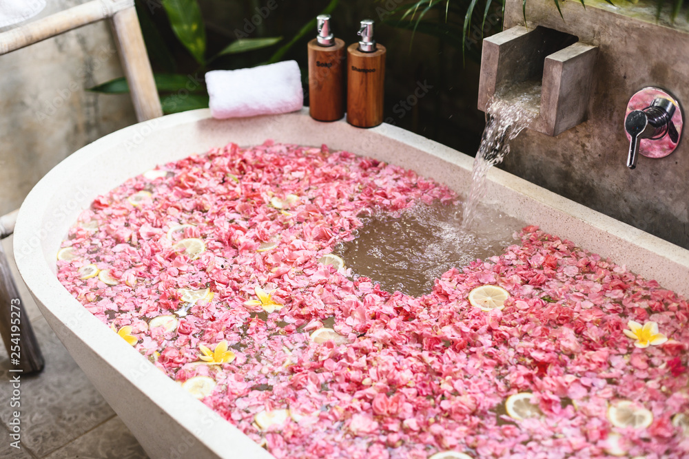 Bath tub with flower petals filling with water