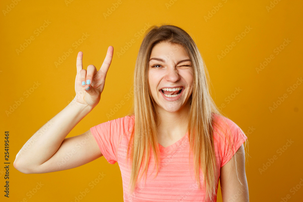 Fototapeta premium Beauty portrait of young adorable fresh looking blonde woman with devil gesture
