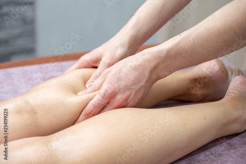 Leg and calf massage. A masseur is doing a massage of legs and calfs