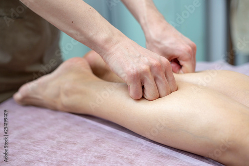 Leg and calf massage. A masseur is doing a massage of legs and calfs