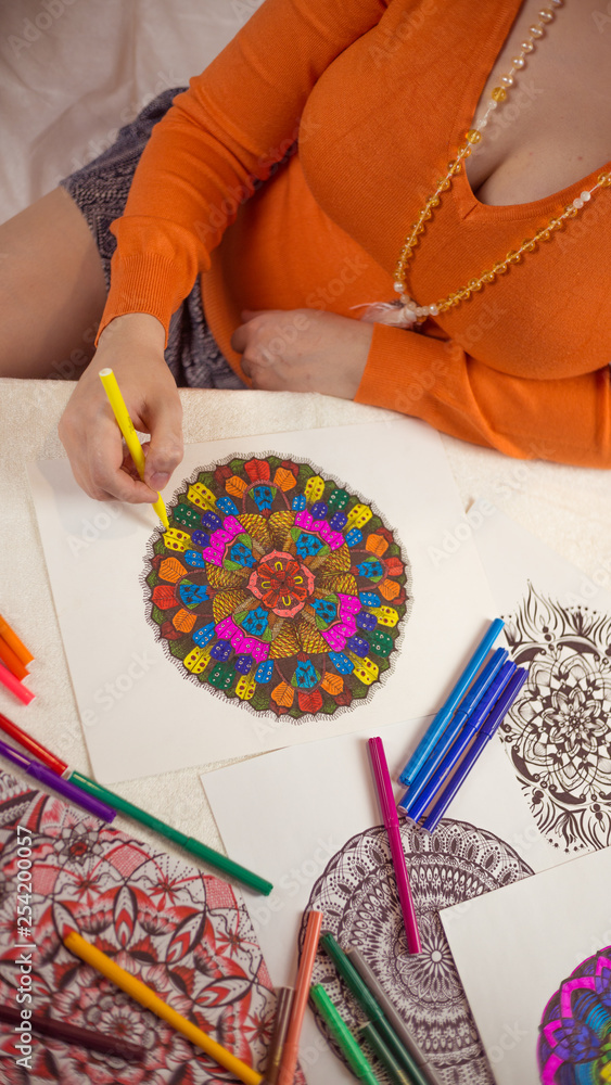 Fototapeta premium The girl draws a mandala