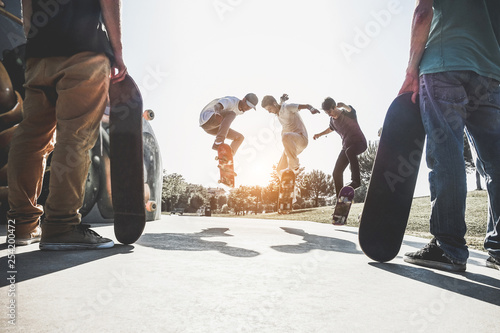 Skaters jumping with skateboard in city skate park - Main focus on center guys heads photo