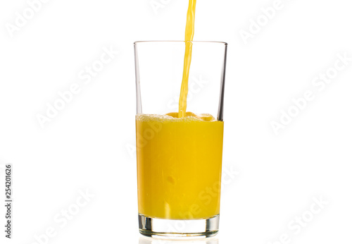 Pouring orange juice into a transparent glass on a white background