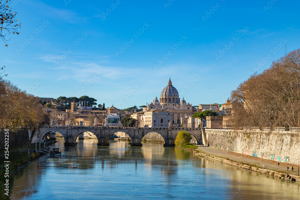 Rome skyline with Vatican St Peter Basilica and St Angelo Bridge crossing Tiber River in the city center of Rome Italy. It is historic landmark of the Ancient Rome and travel destination.