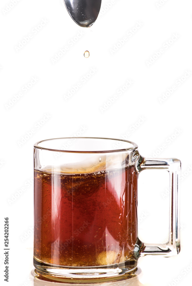 Making tea with sugar from a tea bag in a transparent mug on a white background Making tea with sugar from a tea bag in a transparent mug on a white background