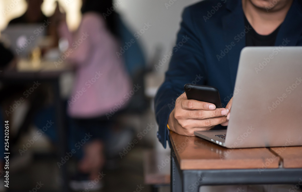Obraz premium Asian business man working with his smartphone in coffee shop in selective focus.