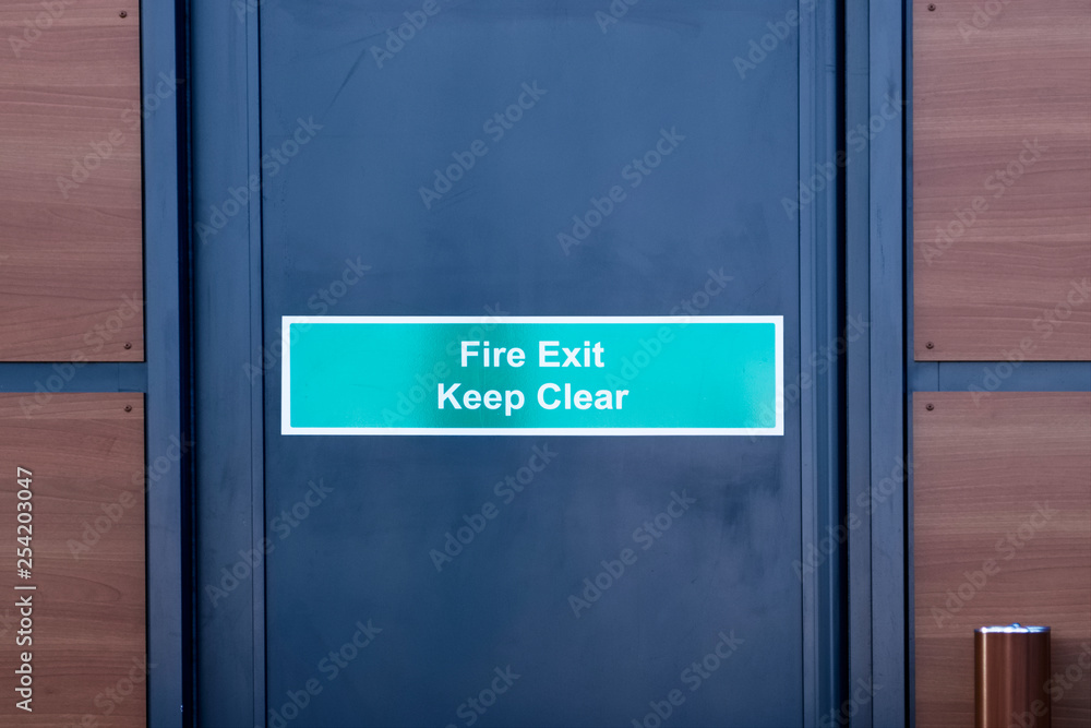 Fire exit keep clear sign on black door