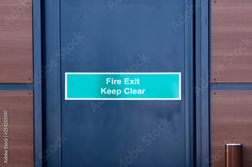 Fire exit keep clear sign on black door © Richard Johnson