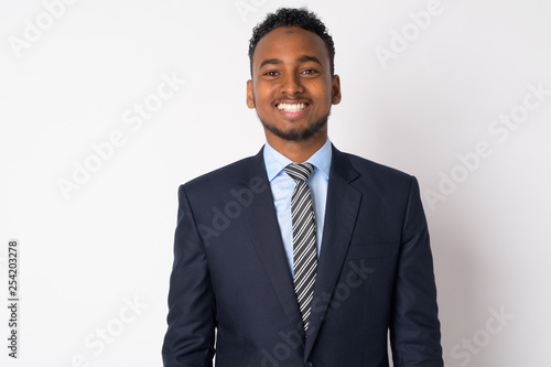Portrait of happy young African businessman in suit smiling
