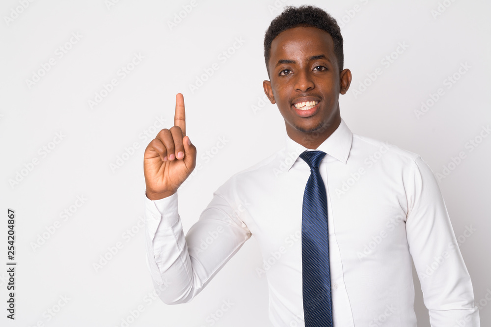 Portrait of happy young African businessman pointing up Portrait of happy young African businessman pointing up