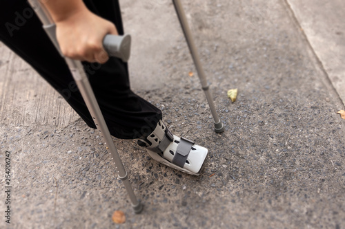 Person walking with walking stick and orthopedi shoe photo