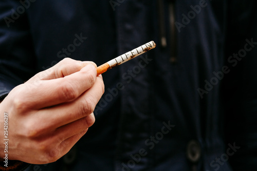 Fototapeta Naklejka Na Ścianę i Meble -  The guy holds a cigarette. Anti nicotine concept. Stop smoking. World No Tobacco Day
