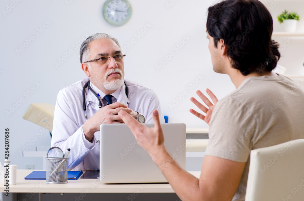 Obraz premium Young man visiting old male doctor 