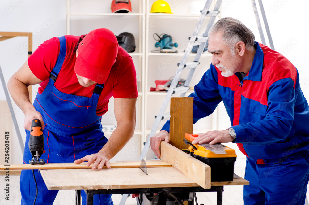 Two professional contractors laying flooring at home Two professional contractors laying flooring at home