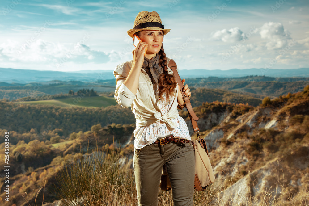 woman hiker on summer hiking in Tuscany ,Italy using smartphone